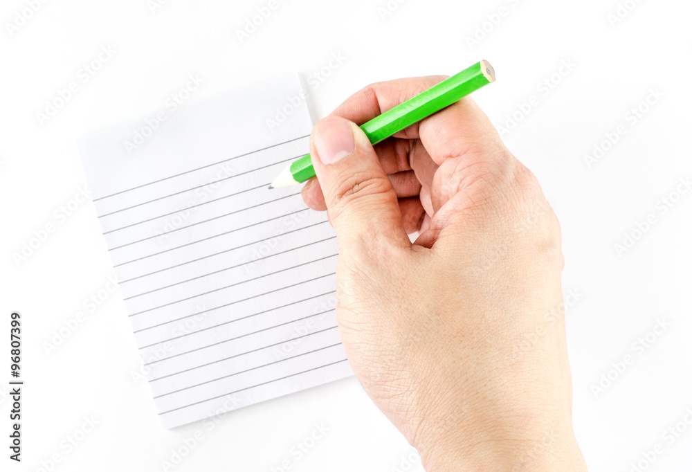 Hand holding green pencil writing on ruled note pad isolated on Hand holding green pencil writing on ruled note pad isolated on