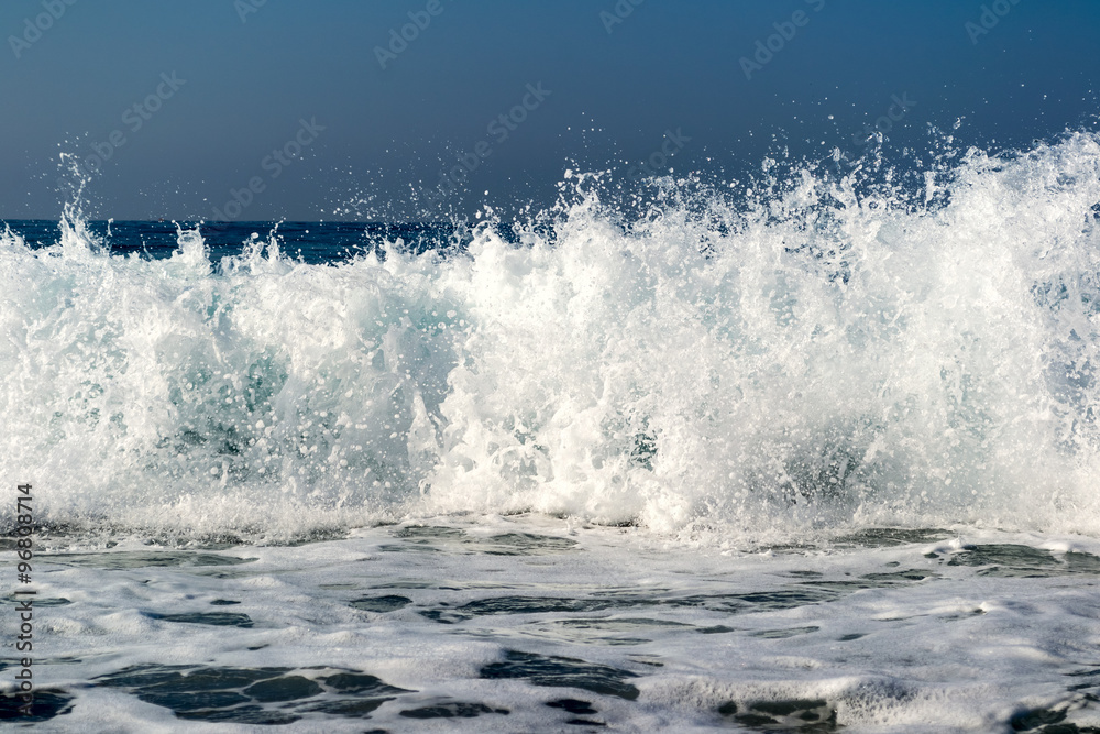 Waves breaking on a stony beach, forming sprays Waves breaking on a stony beach, forming sprays
