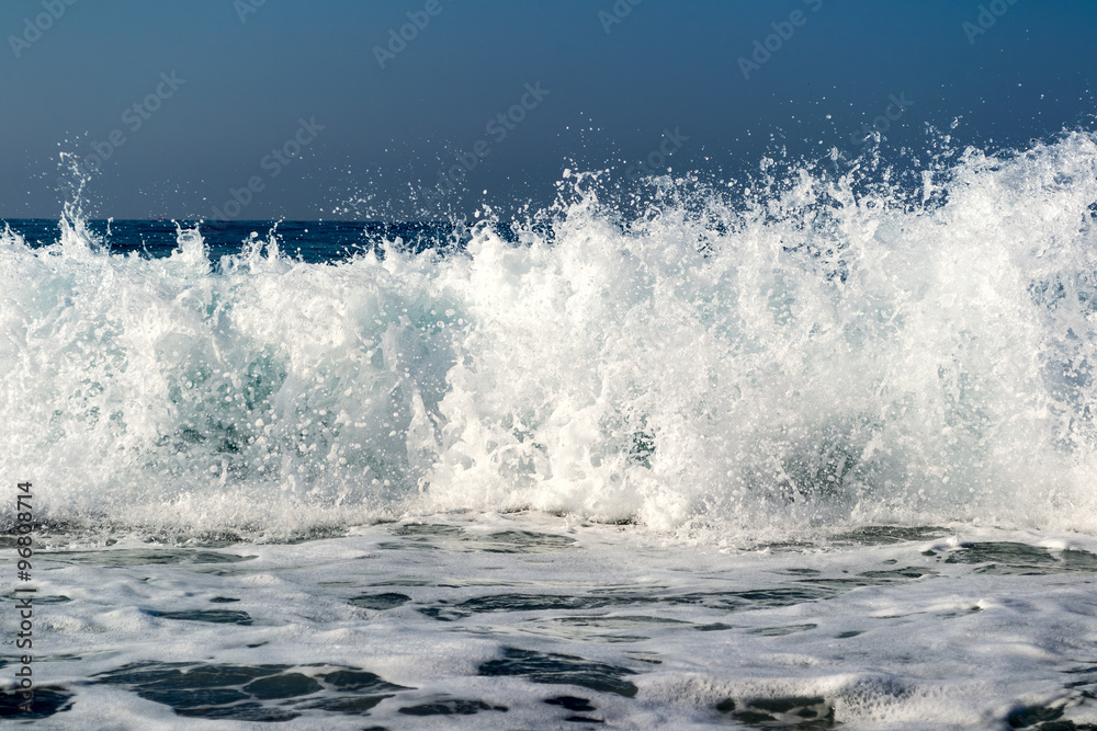 Waves breaking on a stony beach, forming sprays