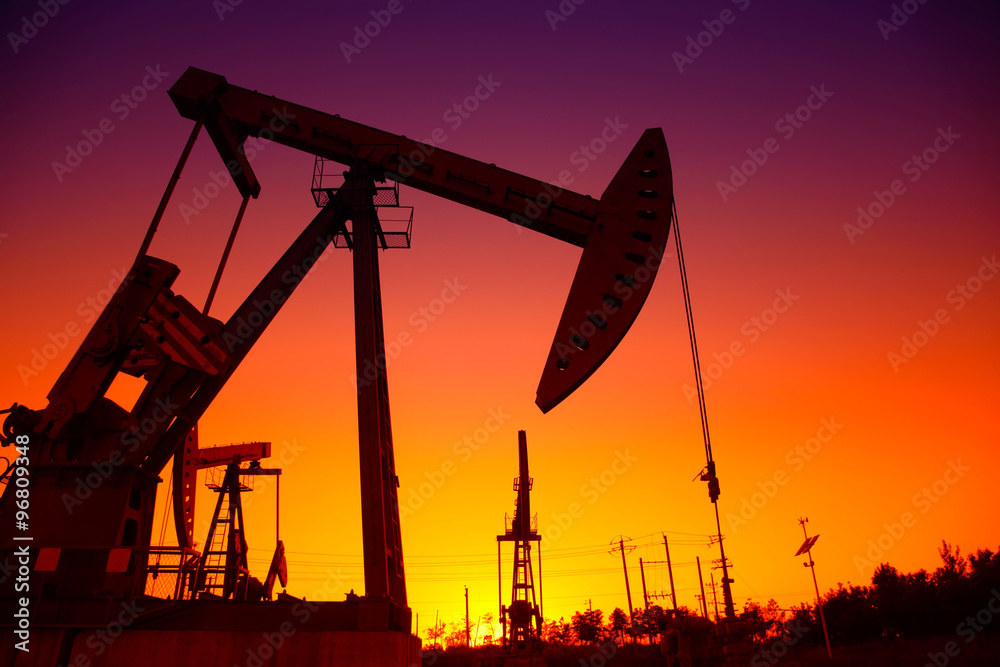Oil field scene, the evening of beam pumping unit in silhouette Oil field scene, the evening of beam pumping unit in silhouette