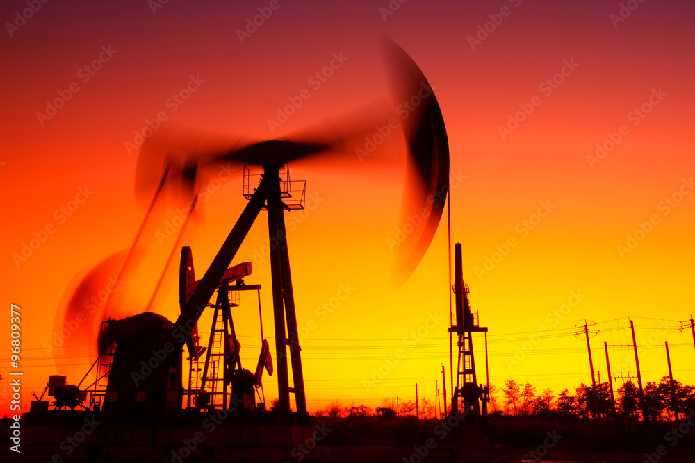 Oil field scene, the evening of beam pumping unit in silhouette