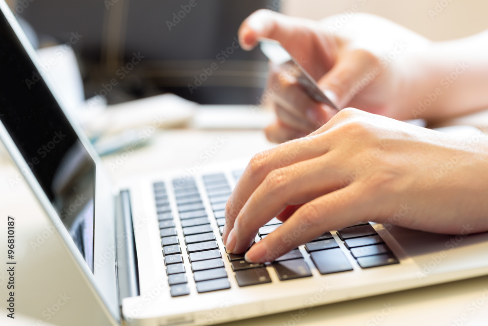 woman holding credit card on laptop for online shopping concept woman holding credit card on laptop for online shopping concept