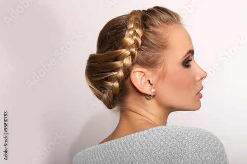 portrait of a beautiful young blonde woman on a light background with hairdo on her head. copy space.