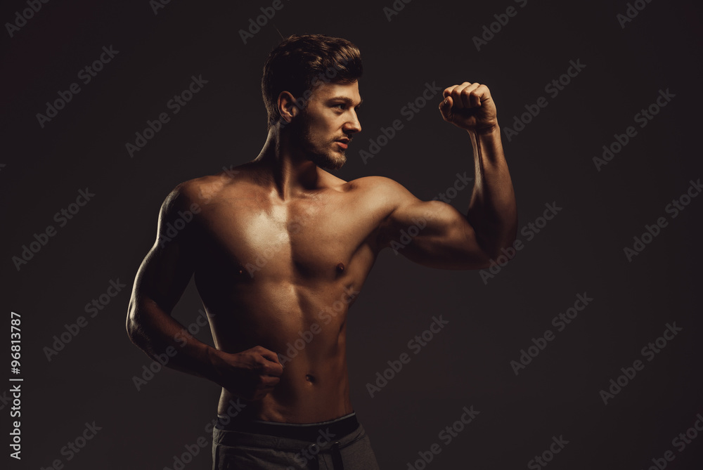 Athletic handsome man showing biceps muscles