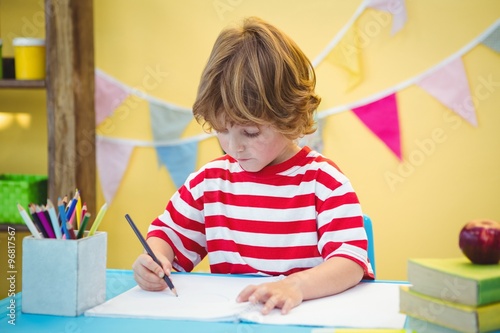 Boy using a pencil to write on paper