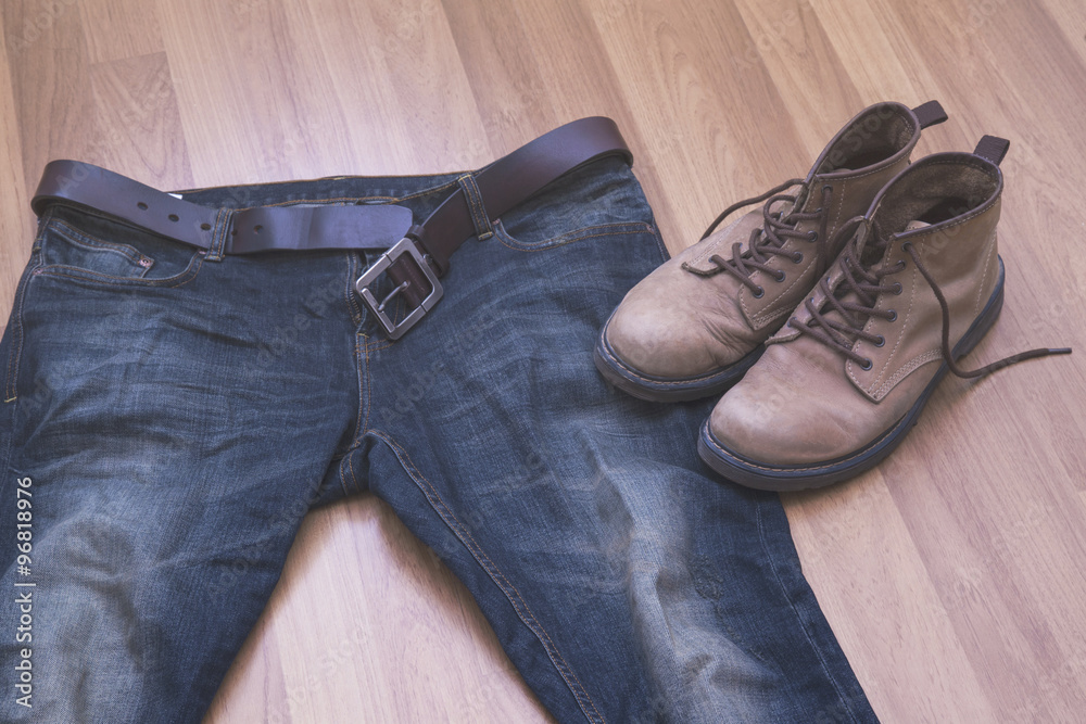 jeans and boots on wooden background jeans and boots on wooden background