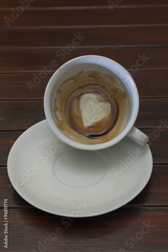 Cup of coffee with Heart of Coffee Grounds, on wooden table, fortunetelling, divination symbol of love