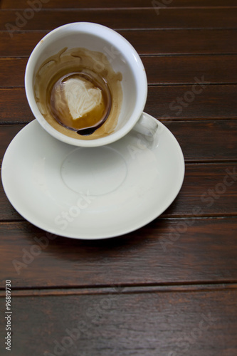 Cup of coffee with Heart of Coffee Grounds, on wooden table, fortunetelling, divination symbol of love