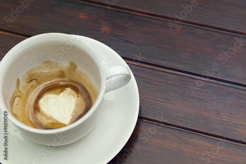 Cup of coffee with Heart of Coffee Grounds, on wooden table, fortunetelling, divination symbol of love