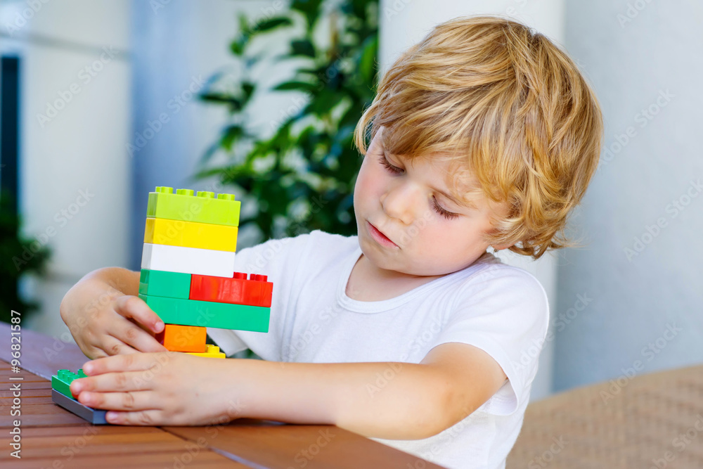 Little kid boy playing with plastic blocks Little kid boy playing with plastic blocks
