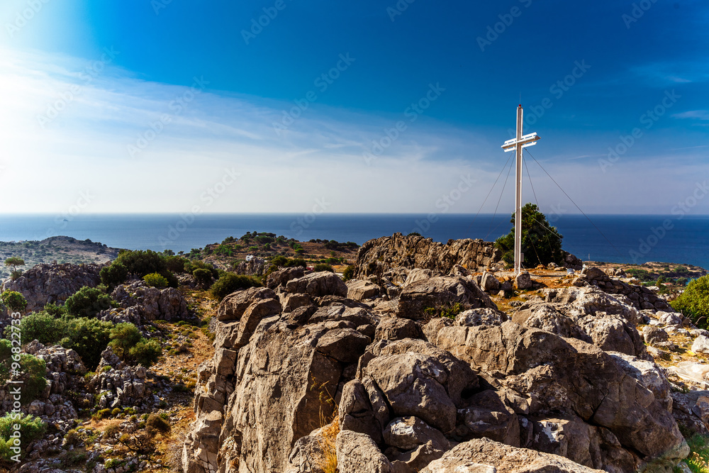 Greece, island Rhodes. Top view to the sea and cross near a chap
