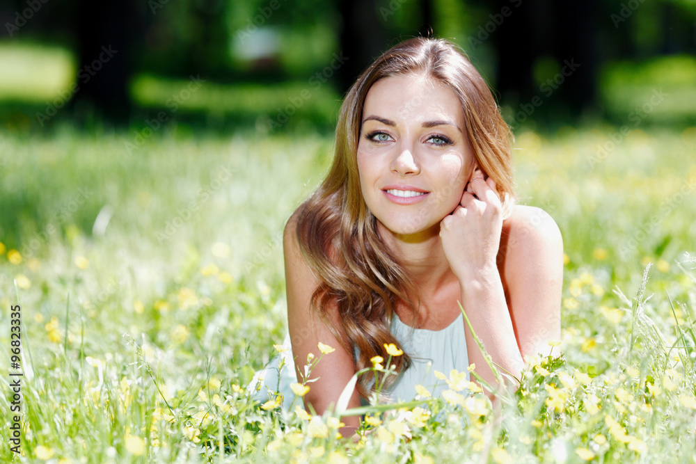 young woman in blue dress lying on grass young woman in blue dress lying on grass