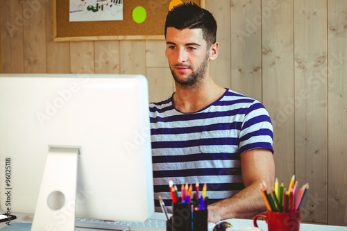 Handsome hipster working at desk