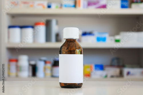 Blank white label of medicine bottle with blur shelves of drug i