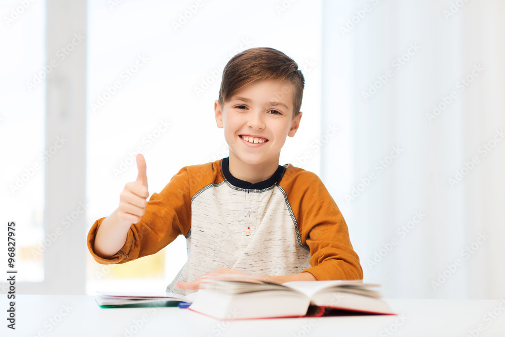 happy student boy with textbook showing thumbs up happy student boy with textbook showing thumbs up
