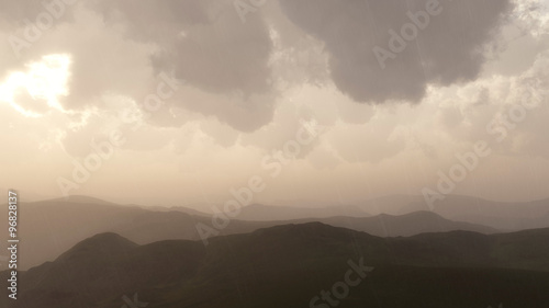 Mountain landscape in rain with stormy sky.