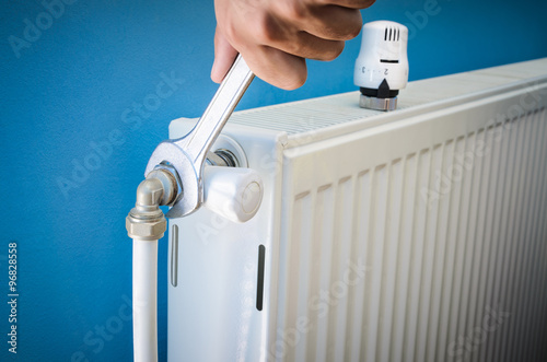 Man installing radiator valve close up photo