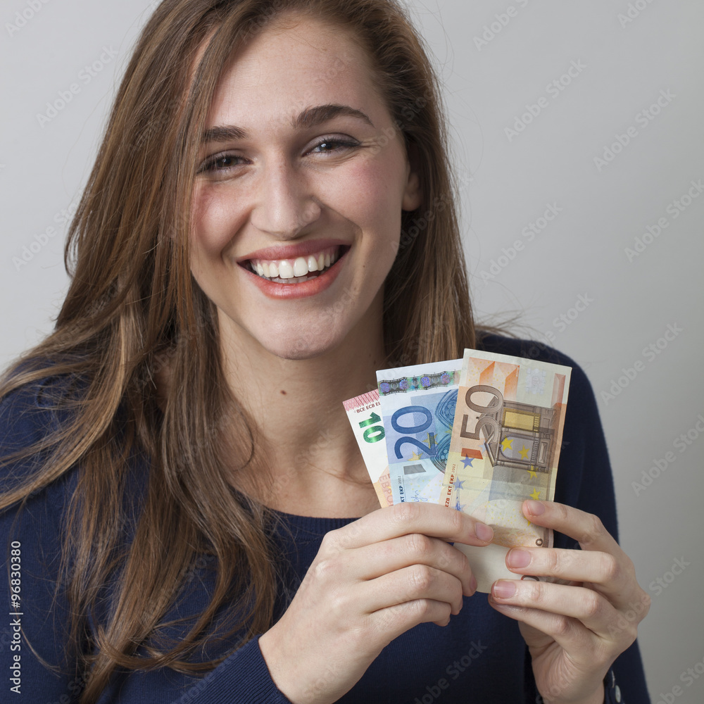 value for money concept - portrait of laughing 20s woman holding Euro bills for valuable earnings or economic wellbeing,studio shot value for money concept - portrait of laughing 20s woman holding Euro bills for valuable earnings or economic wellbeing,studio shot