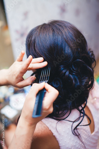 makeup artist preparing beautiful luxury stylish brunette bride hair for special wedding day