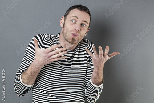 body language concept - talkative 40s man enjoying discussing with expressive himself with fun hand gesture,studio shot on gray background