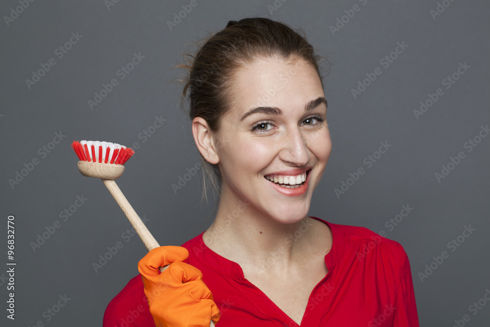 fun cleaning concept - attractive 20s girl holding a dish brush with pride for efficient and satisfying housekeeping,studio shot fun cleaning concept - attractive 20s girl holding a dish brush with pride for efficient and satisfying housekeeping,studio shot