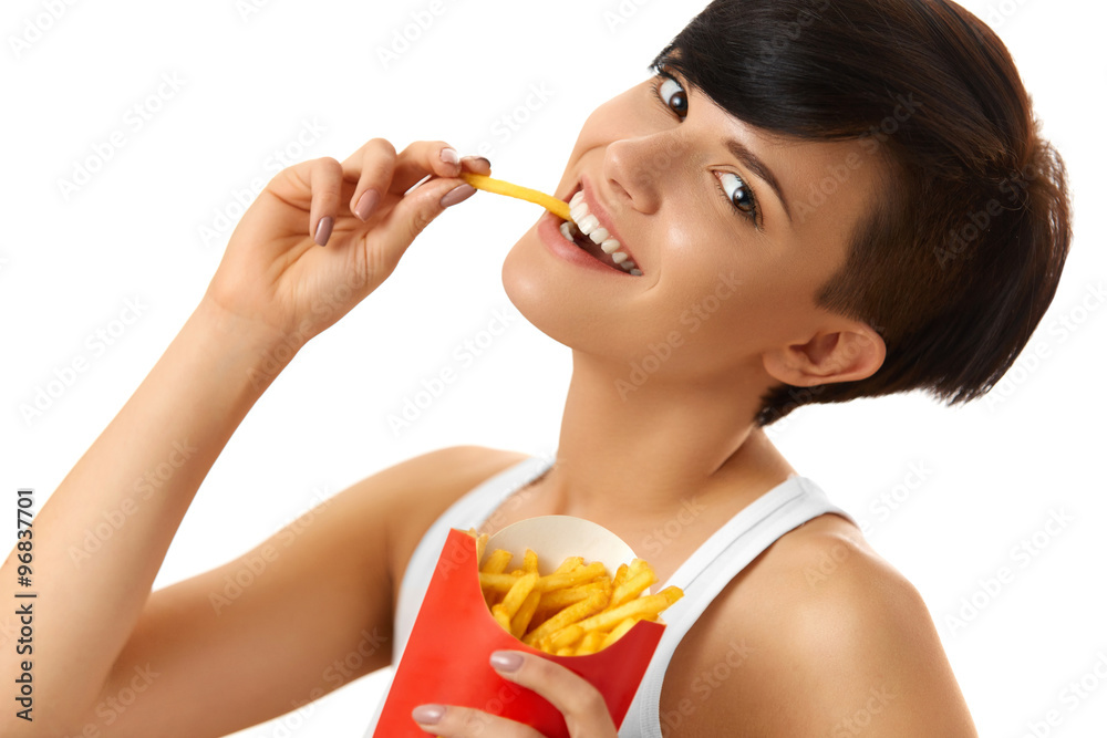 Eating Food. Close-up Of A Smiling Beautiful Woman Holding Red Carton Box With French Fries Chips ( Fried Potatoes ) In Her Hand Against A White Background. Fast Food. Nutrition, Lifestyle Eating Food. Close-up Of A Smiling Beautiful Woman Holding Red Carton Box With French Fries Chips ( Fried Potatoes ) In Her Hand Against A White Background. Fast Food. Nutrition, Lifestyle
