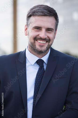 Smiling businessman in black suit