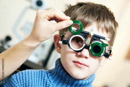 Konstfotografi Optometrist doctor examines eyesight of child boy with phoropter