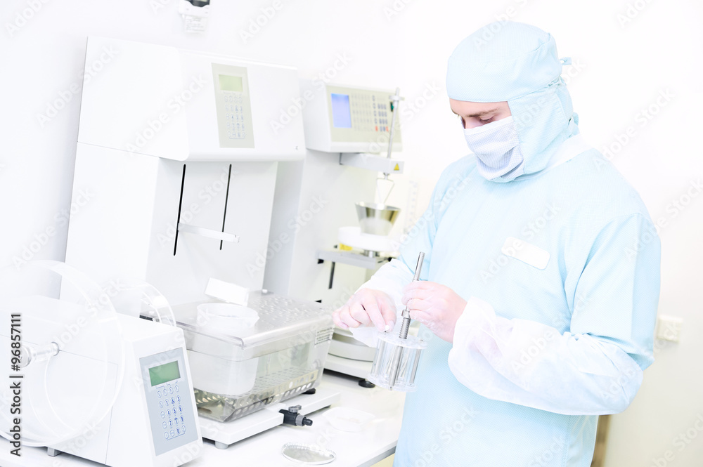 Pharmaceutical researcher with friability and abrasion tester in laboratory Pharmaceutical researcher with friability and abrasion tester in laboratory