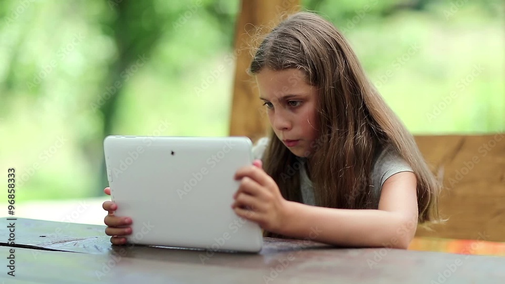 Attractive girl with tablet computer sits at the table in summerhouse. Girl playing the game on tablet computer. Pretty girl with tablet PC sits at the table in bower
Attractive girl with tablet computer sits at the table in summerhouse. Girl playing the game on tablet computer. Pretty girl with tablet PC sits at the table in bower