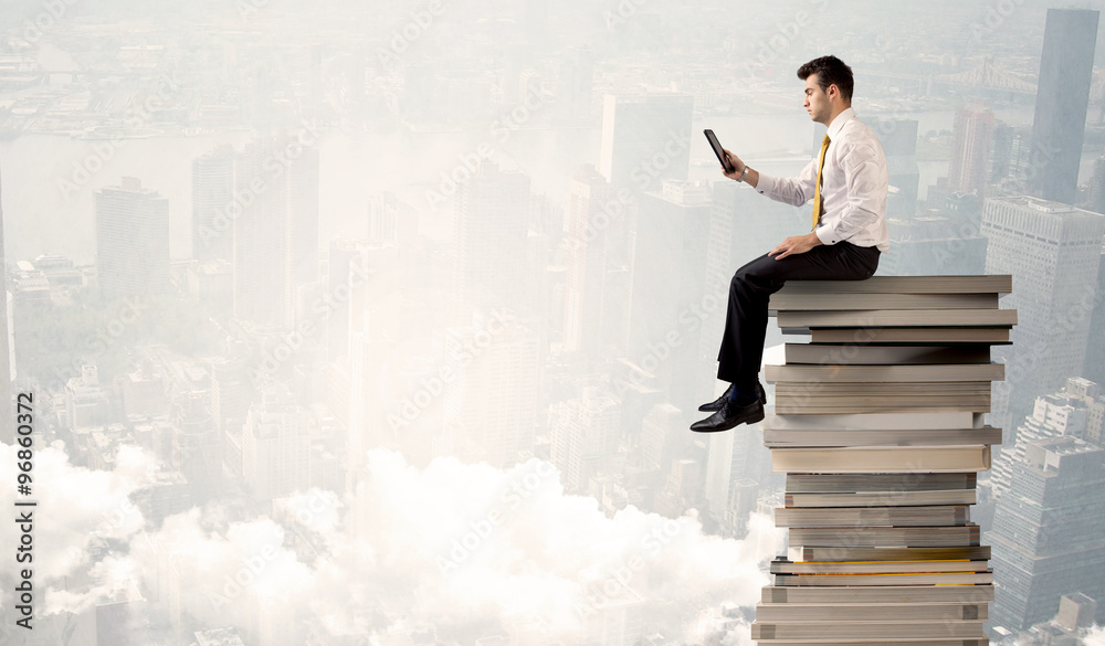 Student in city sitting on stack of books Student in city sitting on stack of books