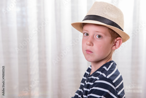 young boy with hat looking angry into the camera