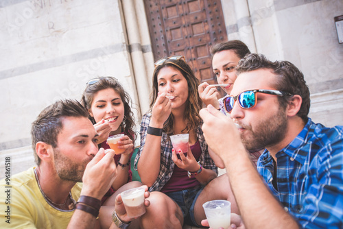 Tourists eating slush, talking and looking each other
