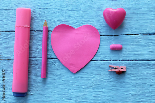 Heart sticky note, peg, label tag,fish star, pen, higlighter and crayons on wooden background photo