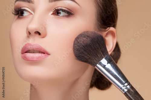 Quadro em tela Attractive young woman is getting make-up at salon