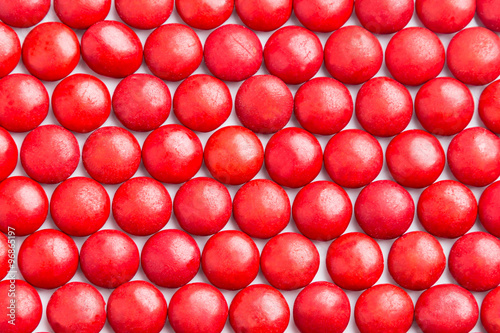 Close up neatly arranged red milk chocolate candies crisp shell