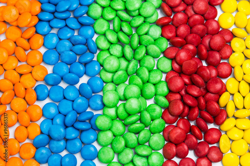 Pile of colorful chocolate candy by color in rows columns