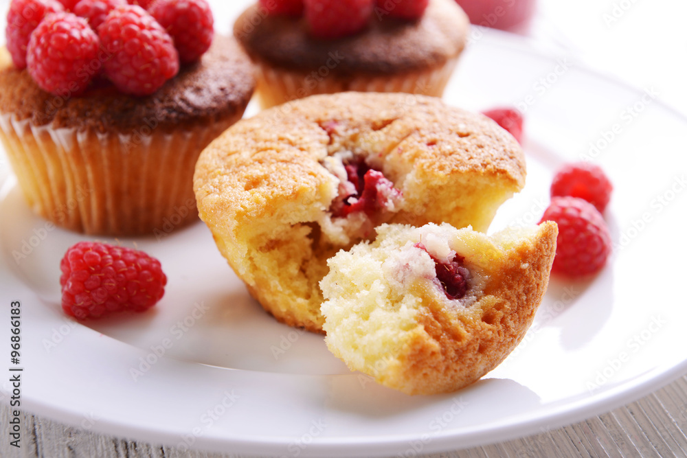 Delicious cupcakes with berries on plate close up Delicious cupcakes with berries on plate close up