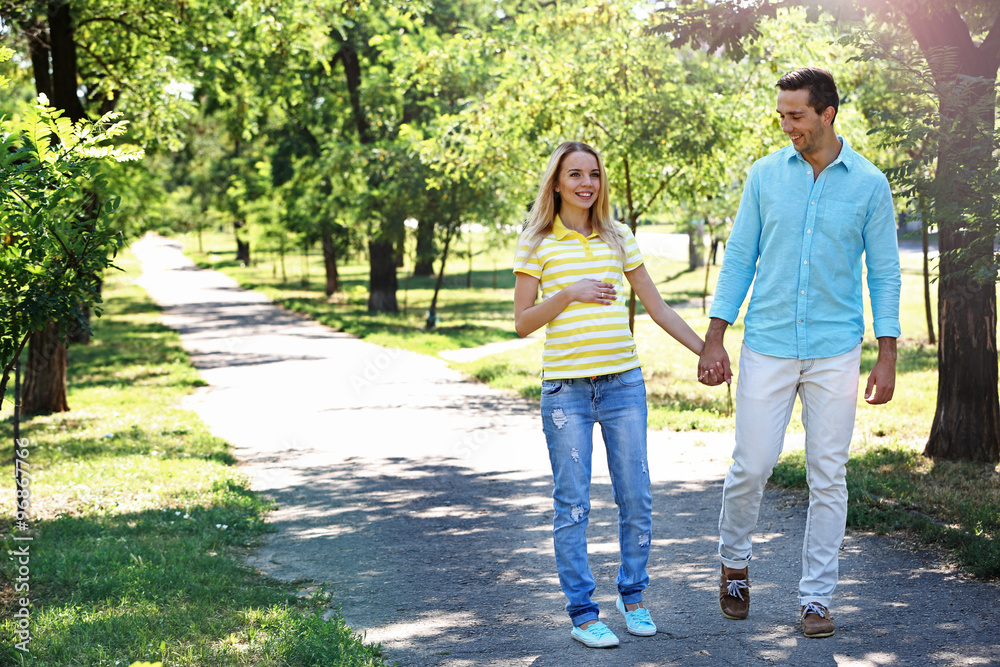 Young pregnant woman with husband walking in park Young pregnant woman with husband walking in park