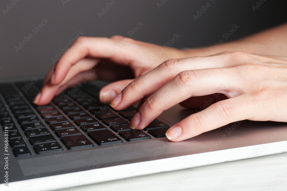 Female hands typing on laptop keyboard, closeup Female hands typing on laptop keyboard, closeup