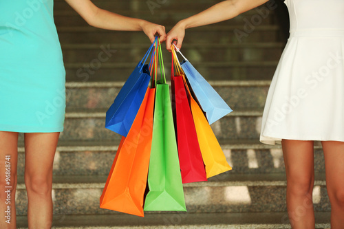 Beautiful young women with shopping bags on steps