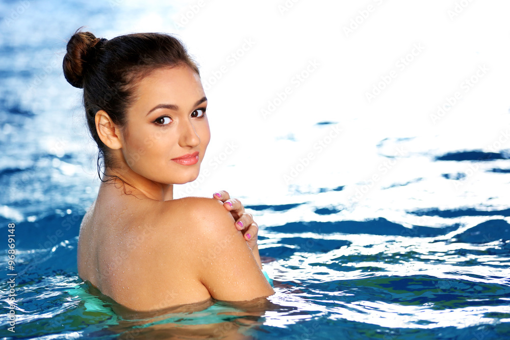 Beautiful young woman at swimming pool