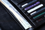 Black leather wallet with credit cards and money, close up