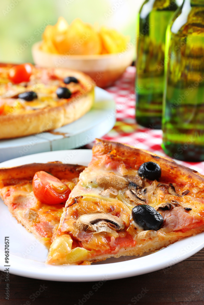 Sliced pizza served with beer on wooden table Sliced pizza served with beer on wooden table
