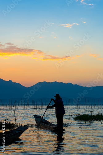 Silhouettes of the traditional fishermen throwing fishing net du