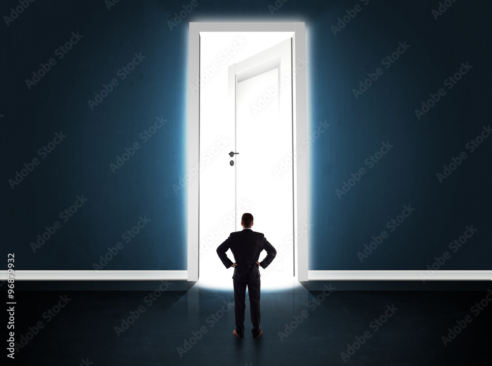 Fototapeta premium Business man looking at big bright opened door