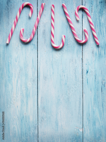 Candy canes on blue wooden background.