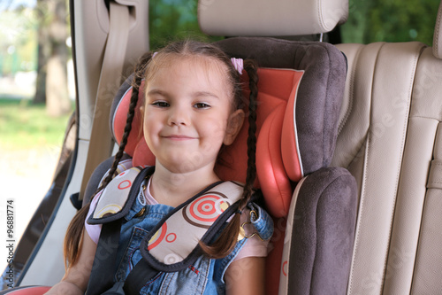 Cute little girl sitting in...