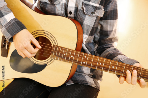 Guitarist plays guitar in the studio, close up