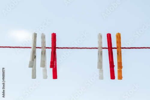 White, Red, Orange Cloth Pins Hanging on Red Rope